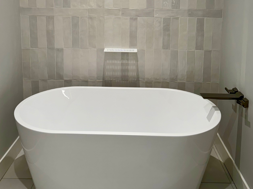 Gray toned wall tile accent wall behind freestanding tub